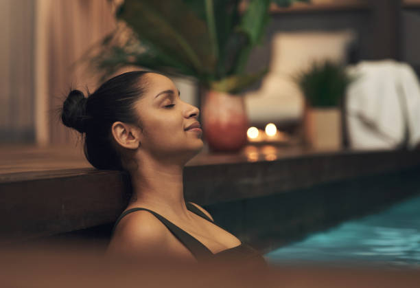 plan d’une jeune femme se relaxant dans une piscine d’un spa - health spa swimming pool relaxation indoors photos et images de collection