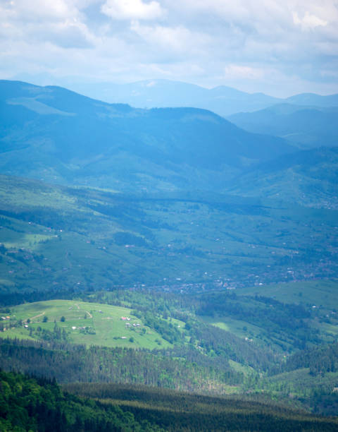 das dorf unter den bergen in sonne und regen - eastern europe mountain range mountain village stock-fotos und bilder