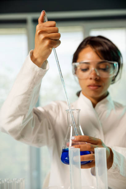 istock Female scientist pouring taking a sample of liquid with a pipette 1325100886