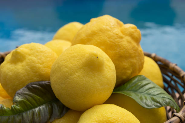istock lovely yellow lemons in a basket and blue water 1325100974