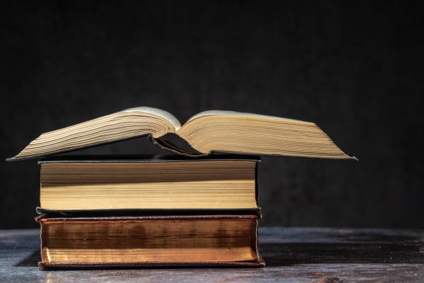 istock A stack of old books lying on a table on a dark background 1325102145