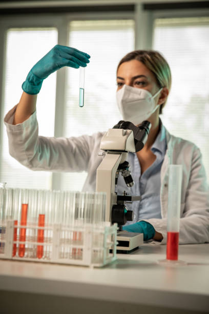 istock Female scientist doing an experiment and analyzing liquid sample in a test tube 1325102475