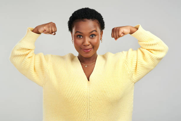 istock Shot of a young woman flexing while posing against a grey background 1325102529