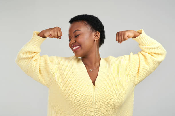istock Shot of a young woman flexing while posing against a grey background 1325102531