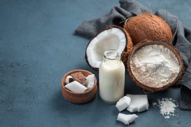 latte di cocco, farina e noci di cocco su sfondo blu - powdered coconut foto e immagini stock