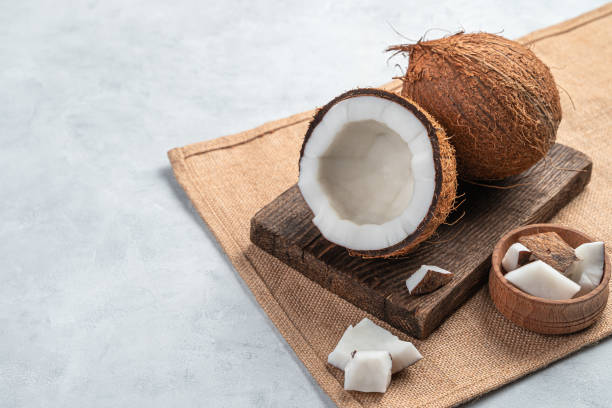 istock A whole and open coconut with pieces on a gray background 1325108467