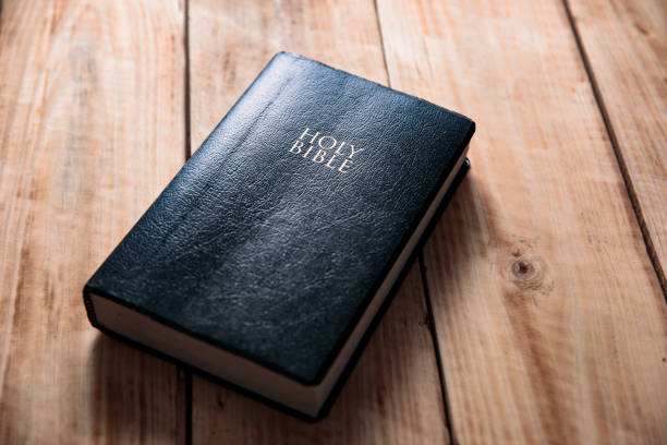 santa biblia sobre la mesa de madera - biblia fotografías e imágenes de stock