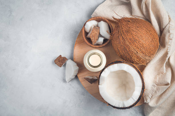 istock Coconuts and coconut milk on a wooden board on a gray background 1325109377