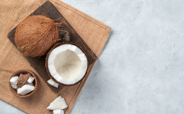 istock An open coconut on a wooden board on a light pink background 1325109414