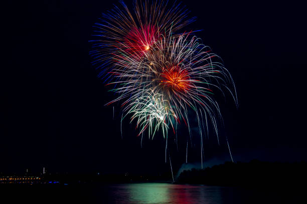 istock A huge multicolored firework ball over a big night city is reflected in the river. 1325110412