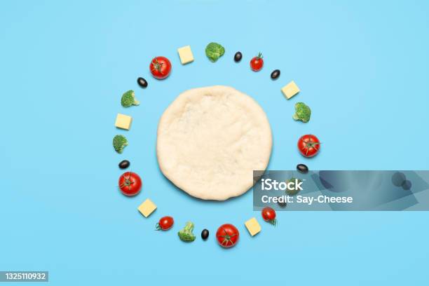 Vegan Pizza Ingredients Top View Raw Pizza Dough And Vegetables On Blue Table Stock Photo - Download Image Now