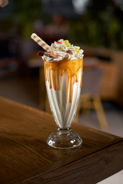 Extreme milkshake with marmalade and candy inside the interior of modern cafe. Extreme milkshake. Overshake. Freakshake with marmalade and candy inside the interior of modern cafe. milkshake stock pictures, royalty-free photos & images