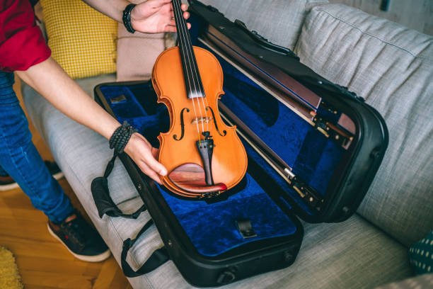 istock Hands of a man placing his  violin in a case 1325116599