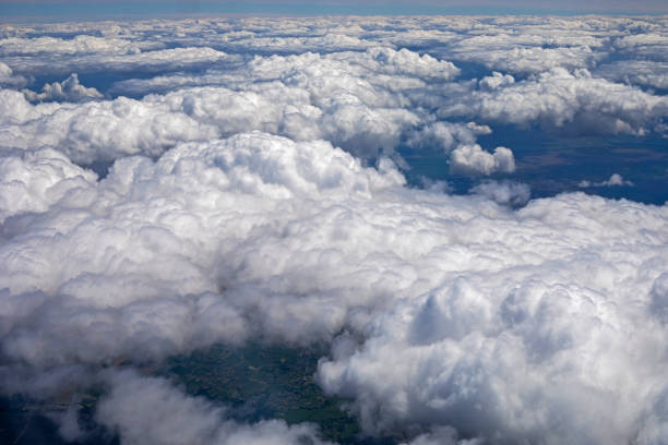 istock sky with thunderous white clouds above the ground view from the airplane window, horizontal 1325116758