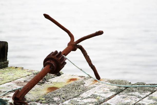 istock Antique boating anchor sitting on an old wharf 1325117659