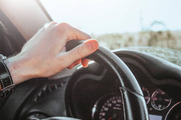istock Hand holding steering wheel in a Car 1325121216