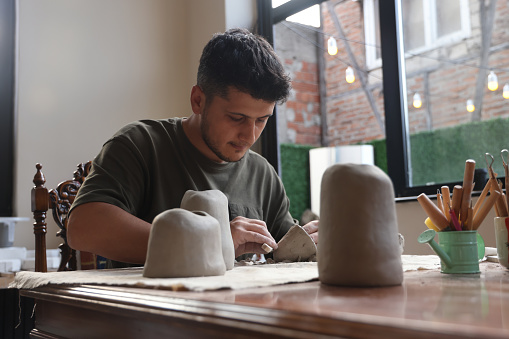 Ceramic artist sculpting clay and making bowls