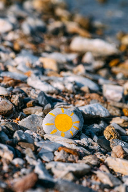 istock Sun Painted on Pebbles on the Beach 1325122276