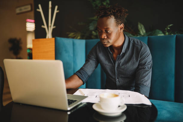 istock Young man doing work on the laptop in the cafe 1325137992