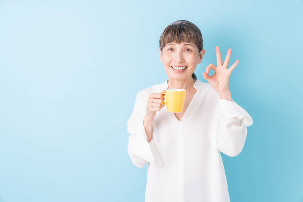 старший возраст женщина, которая пьет кофе - coffee cup flash стоковые фото и изображения