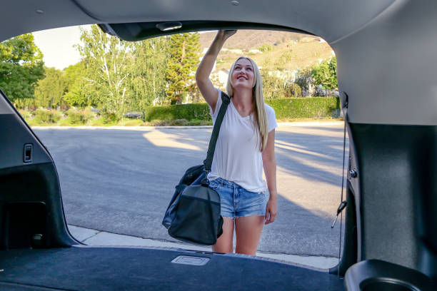istock Young woman at car trunk with bag 1325145210