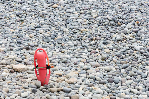 Red plastic buoyancy aid in the sand on lonely beach
