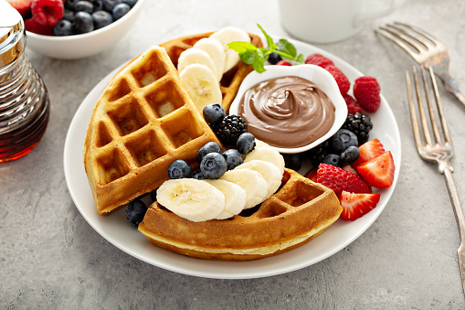 Waffles with berries and chocolate sauce for breakfast