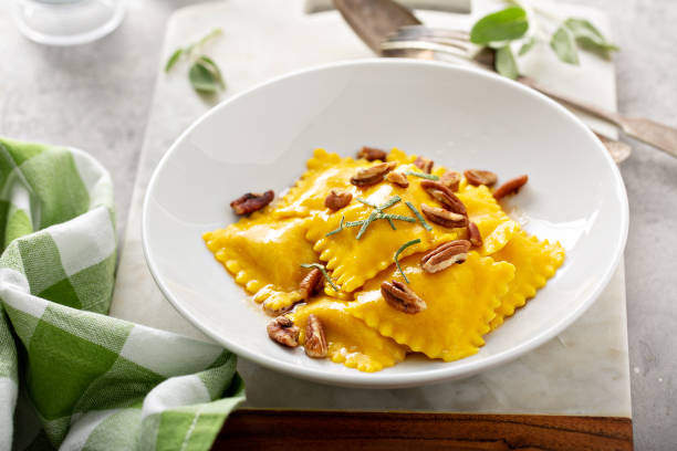 Butternut squash tortellini with brown butter and pecans Pumpkin or butternut squash tortellini with brown butter and pecans mezzaluna stock pictures, royalty-free photos & images