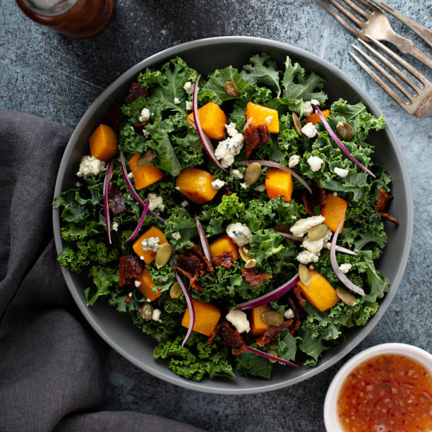 Fall salad with kale and butternut squash Fall salad with kale and butternut squash, blue cheese and hot bacon dressing kale photos stock pictures, royalty-free photos & images