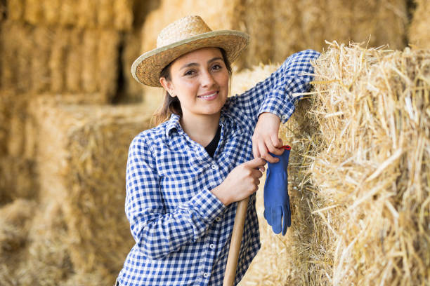 istock Young woman farmer posing near straw stack 1325161793