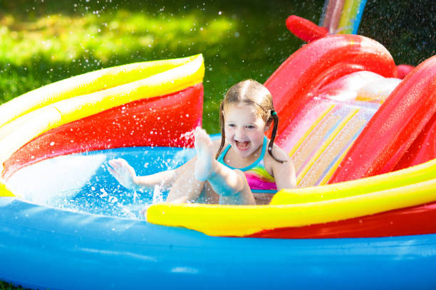 istock Child in garden swimming pool with slide 1325161890