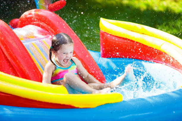 istock Child in garden swimming pool with slide 1325161907
