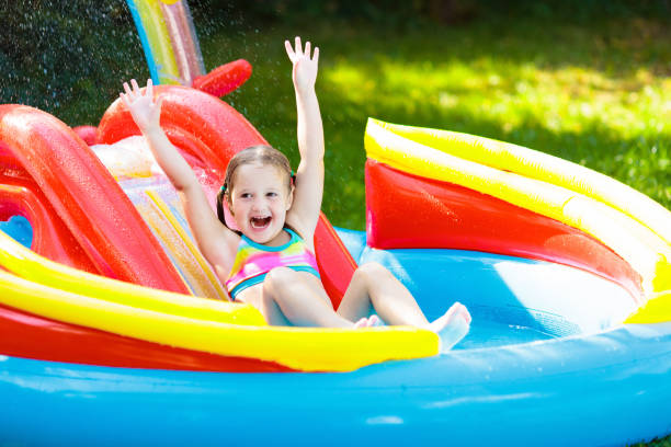 istock Child in garden swimming pool with slide 1325162444