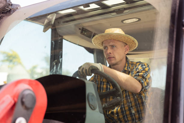 istock Focused busy farmer driving tractor working on farm 1325162845