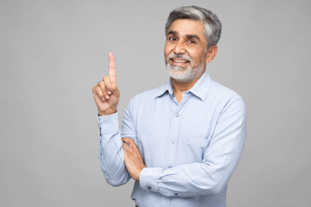 portrait of mature business men standing isolated over gray background:- stock photo - number 1 businessman one finger one person imagens e fotografias de stock