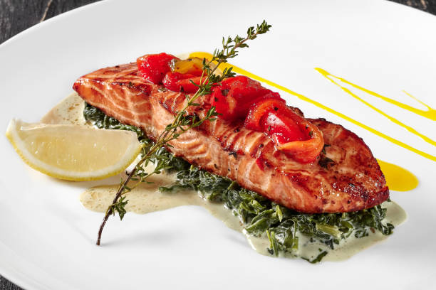 istock Baked salmon steak with spinach stewed in cream and lemon 1325165366