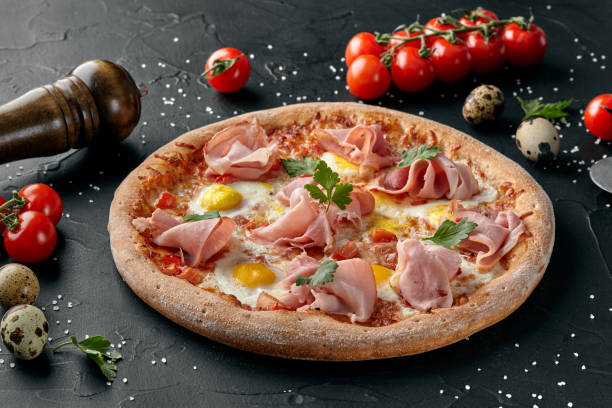 Pizza with tomatoes, mozzarella, ham and quail eggs