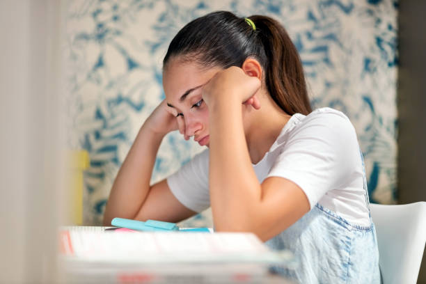 istock Young girl sitting studying her homework at home 1325167412
