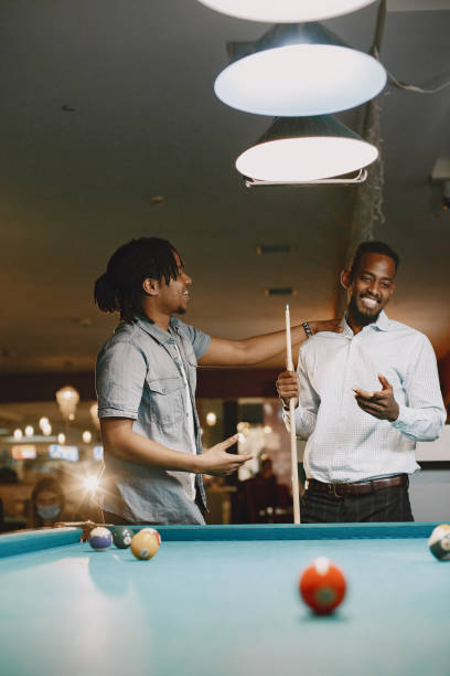 istock Men playing billiards in a club 1325167457