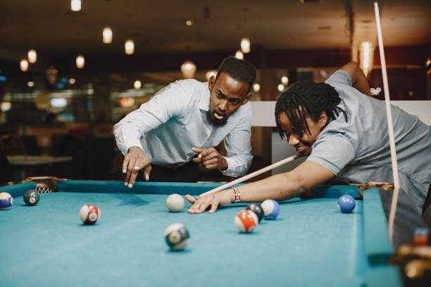 istock Men playing billiards in a club 1325167494