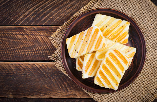 Traditional grilled halloumi cheese on plate on wooden background. Top view, above stock photo