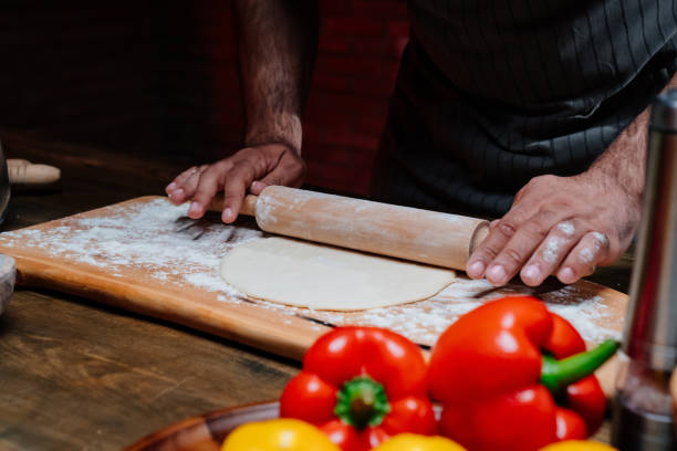 istock hands roll the dough into a thin layer. Cooking pizza, noodles or pitta at home 1325175196