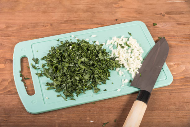 istock Chopped parsley, cilantro and garlic for dressing the dish on a cutting board lying on a wooden table with a knife - Italian, Georgian, Greek cuisine 1325177670