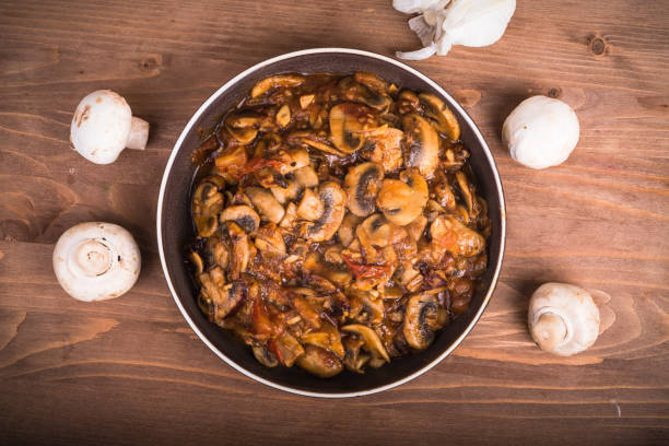 hausgemachter eintopf aus tomaten und champignon-pilzen auf dem teller, ansicht von oben, nahaufnahme - ragout stock-fotos und bilder