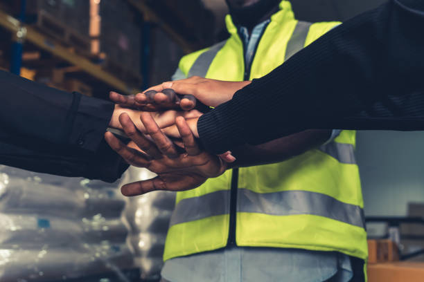 istock Factory workers stacking hands together in warehouse or storehouse 1325178759