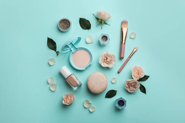 istock Flat lay composition with makeup products, roses and macaron on turquoise background 1325179606