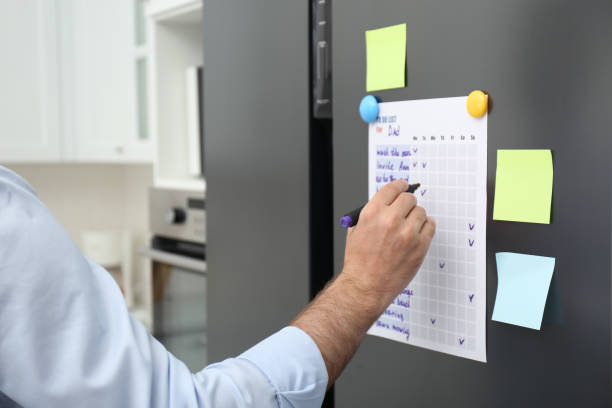istock Man checking to do list on fridge in kitchen, closeup 1325180979
