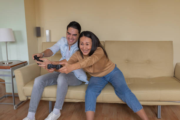 istock Young Woman is Having Fun with her Boyfriend while Playing Computer Games at Home. 1325182097