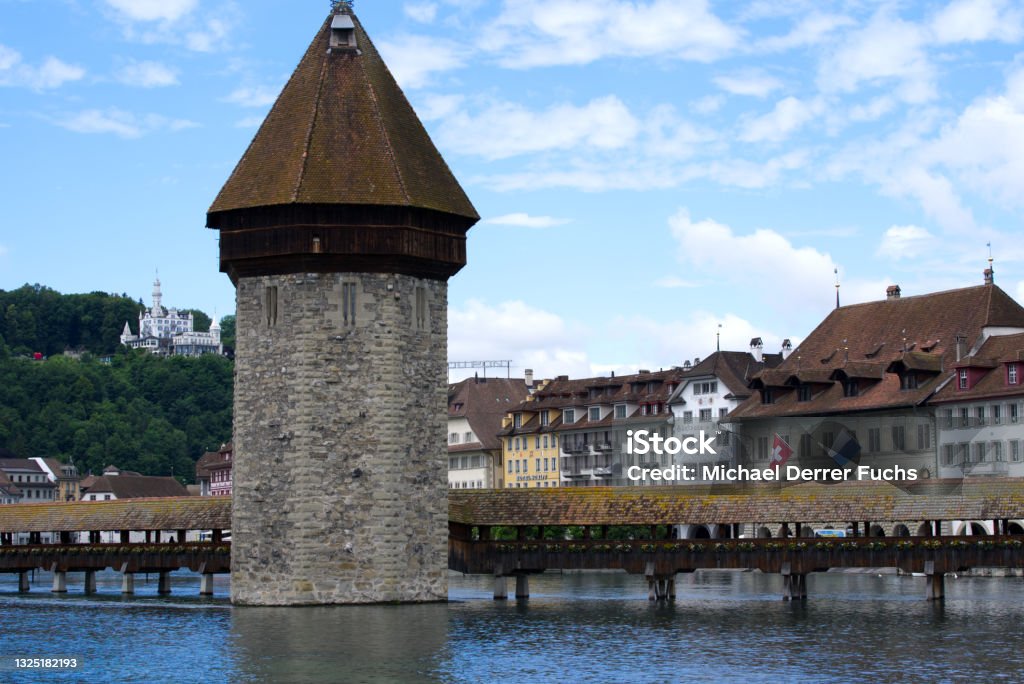 Famous wooden Kappelbrücke (Chapel Bridge) at the old town of Lucerne with medieval stone tower with wooden roof. Photo taken June 22nd, 2021, Luzern, Switzerland. Architecture Stock Photo