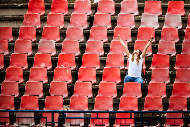 fröhlicher sportfan feiert erfolg ihrer mannschaft im stadion. - bleachers stadium empty seat stock-fotos und bilder